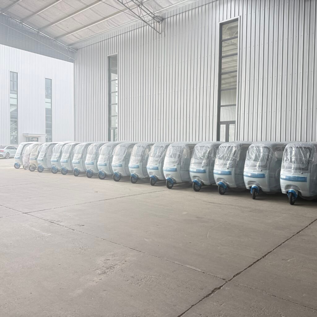 Flota uniforme de triciclos eléctricos azul claro alineada en el almacén