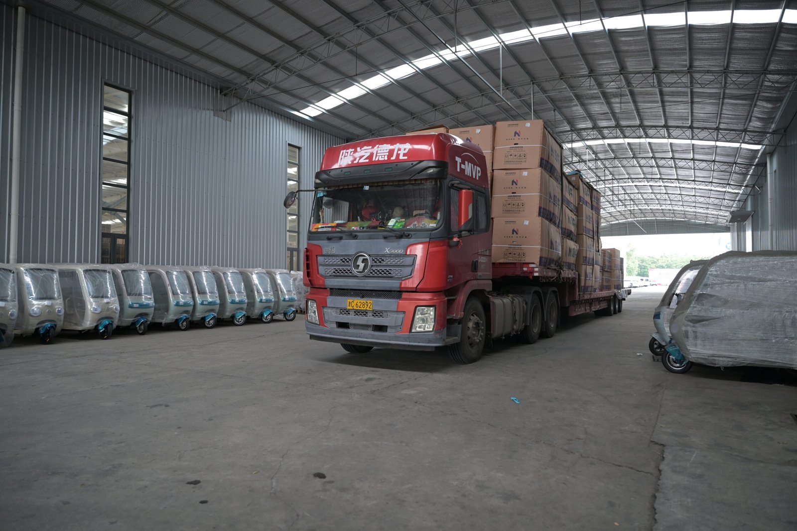 Fábrica Falcon carregando veículos elétricos em caminhão para exportação ao Brasil